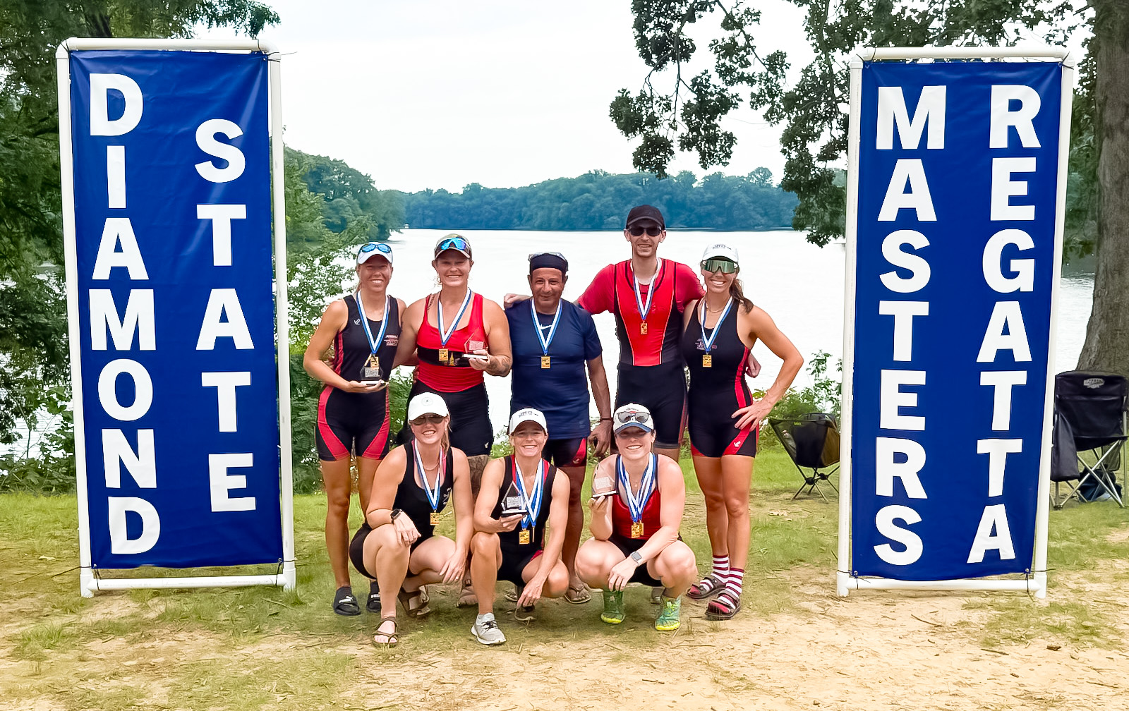 Diamond State 2025 IMG_7509 - CRaw + crop JRC Rowers standing by a river and showing off their race medals