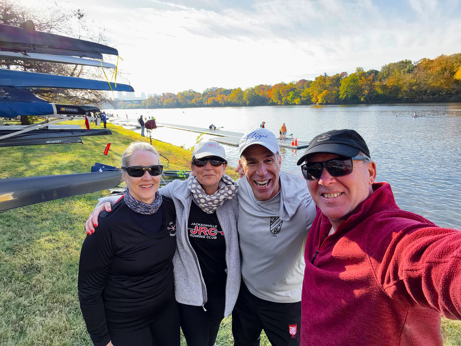 JRC racers posing for a group shot in front of their trailer loaded with rowing shells